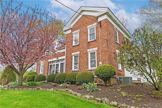 5843 Baer Rd, Cambria, NY 14132 - view of side of home with central AC unit, brick siding, and a lawn
