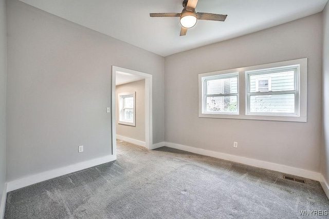 spare room with baseboards, carpet flooring, visible vents, and ceiling fan
