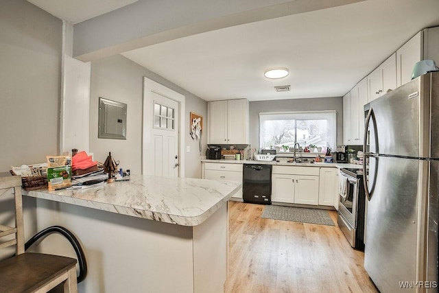 kitchen with light wood finished floors, visible vents, electric panel, light countertops, and appliances with stainless steel finishes