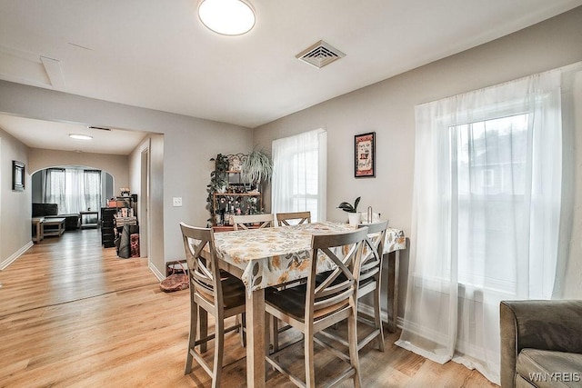 dining room with baseboards, a wealth of natural light, light wood-style flooring, and visible vents