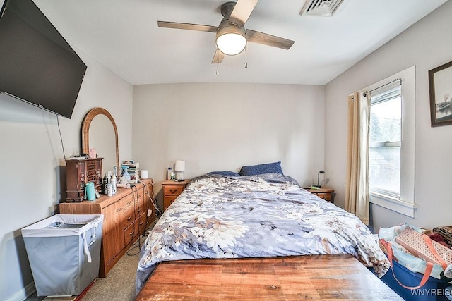 carpeted bedroom featuring visible vents and a ceiling fan