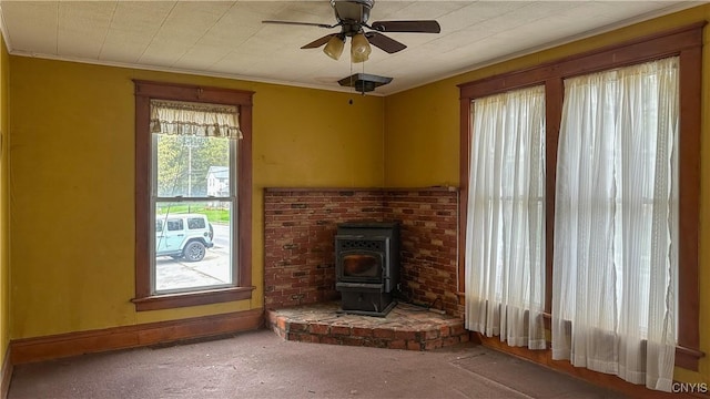 420 Main St, Russia, NY 13324 - unfurnished living room featuring carpet flooring, a wood stove, ornamental molding, and ceiling fan