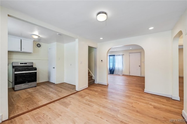 321 Eggert Rd, Cheektowaga, NY 14215 - kitchen with gas stove, arched walkways, light wood-style flooring, white cabinetry, and recessed lighting