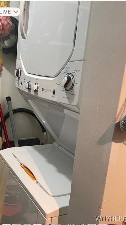 washroom with stacked washing maching and dryer and laundry area