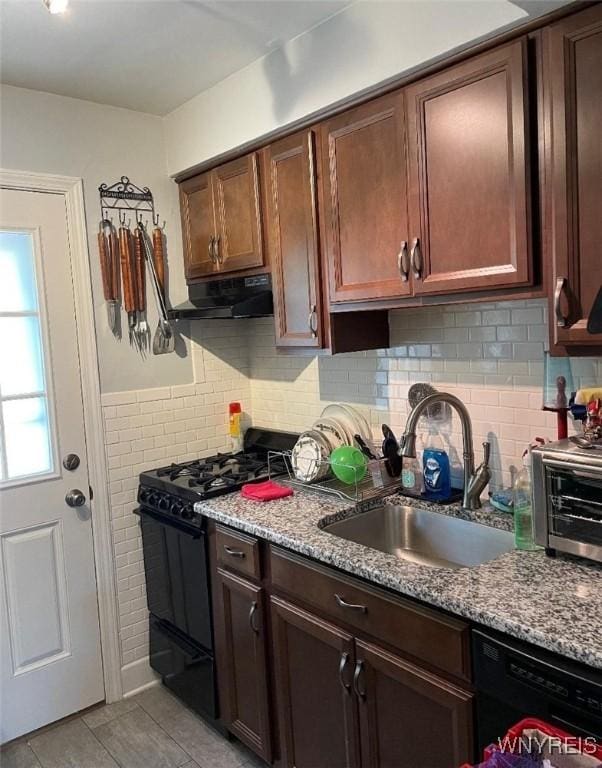 kitchen with a sink, a toaster, black appliances, under cabinet range hood, and light tile patterned flooring