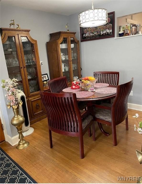 dining space featuring light wood-type flooring and baseboards