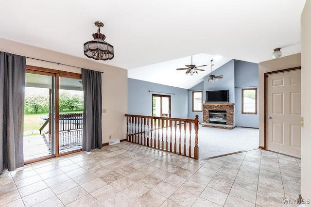 unfurnished living room featuring a brick fireplace, ceiling fan, baseboards, vaulted ceiling, and light carpet