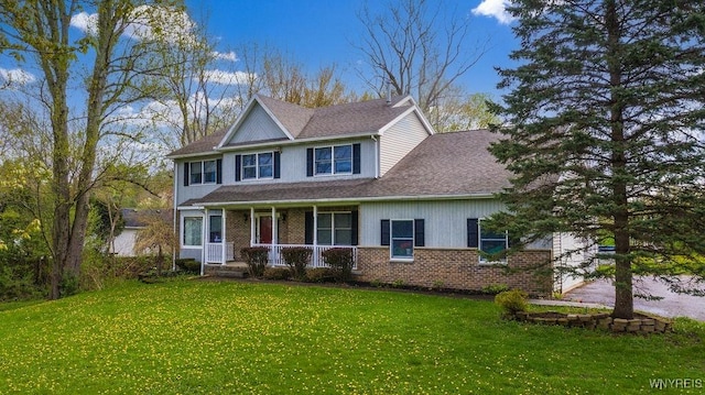view of front of house featuring a porch, a front lawn, brick siding, and roof with shingles