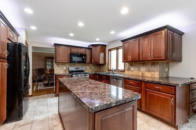 kitchen with black appliances, a sink, recessed lighting, backsplash, and dark stone countertops