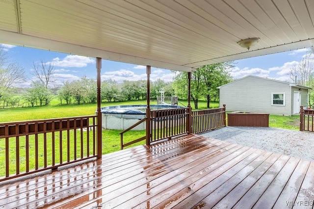 wooden terrace with a pool and a yard