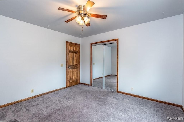 unfurnished bedroom with carpet floors, baseboards, a closet, and a ceiling fan