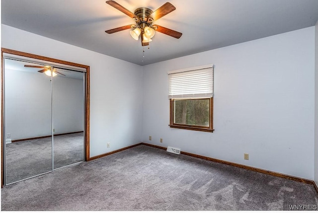 unfurnished bedroom with carpet floors, baseboards, a closet, and a ceiling fan