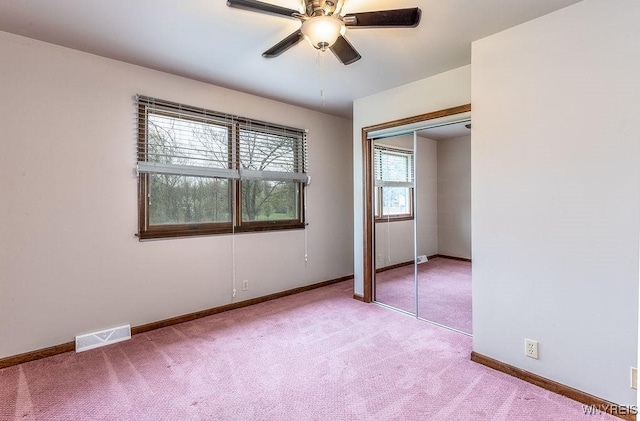 unfurnished bedroom with light carpet, baseboards, a closet, and ceiling fan