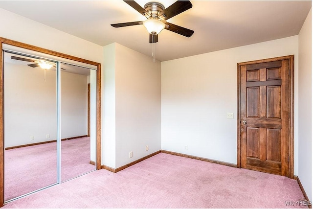 unfurnished bedroom featuring light carpet, a closet, baseboards, and ceiling fan
