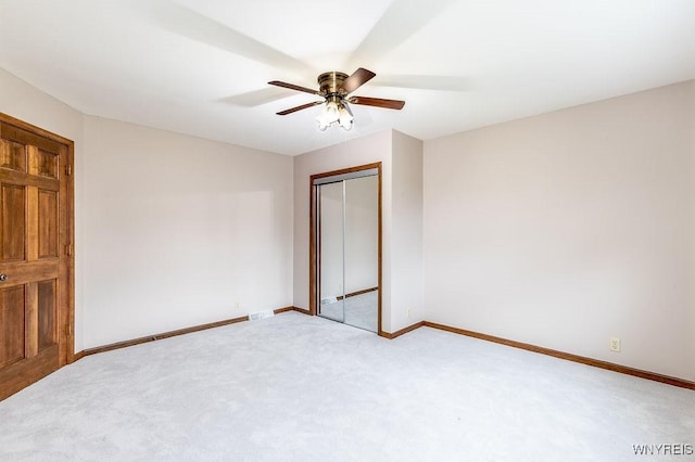 unfurnished bedroom featuring carpet floors, baseboards, a closet, and ceiling fan