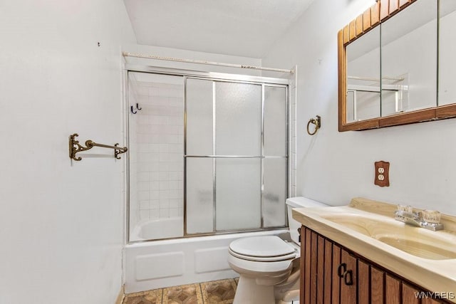 bathroom featuring toilet, vanity, and shower / bath combination with glass door