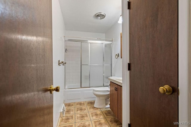 full bathroom featuring toilet, vanity, visible vents, and bath / shower combo with glass door