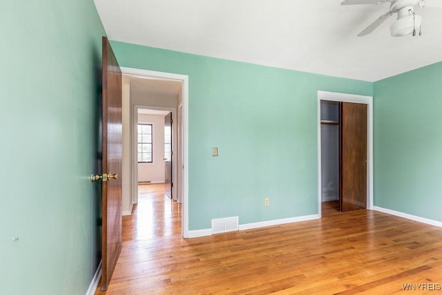 unfurnished bedroom with light wood-style flooring, baseboards, a closet, and visible vents