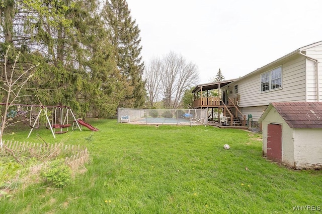 view of yard with a storage shed, fence, a deck, an outbuilding, and stairway