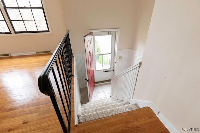 stairway with visible vents and wood finished floors