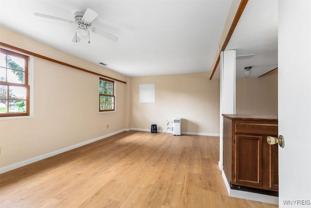 unfurnished living room with ceiling fan, baseboards, light wood-type flooring, and visible vents