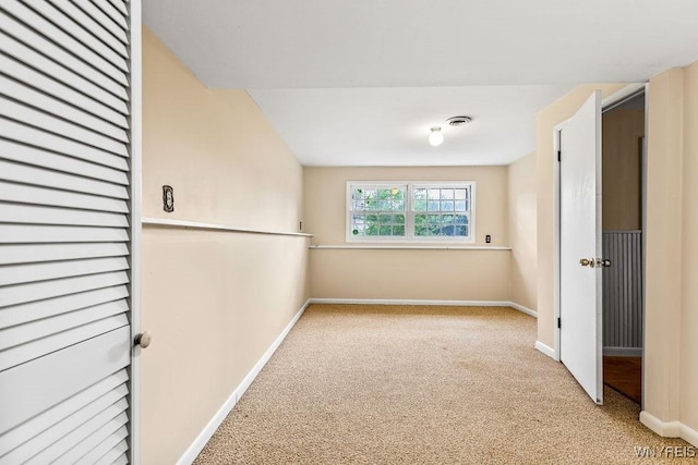 empty room featuring light carpet and baseboards