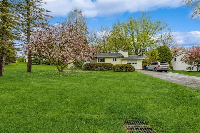 view of front facade with aphalt driveway, a garage, and a front lawn