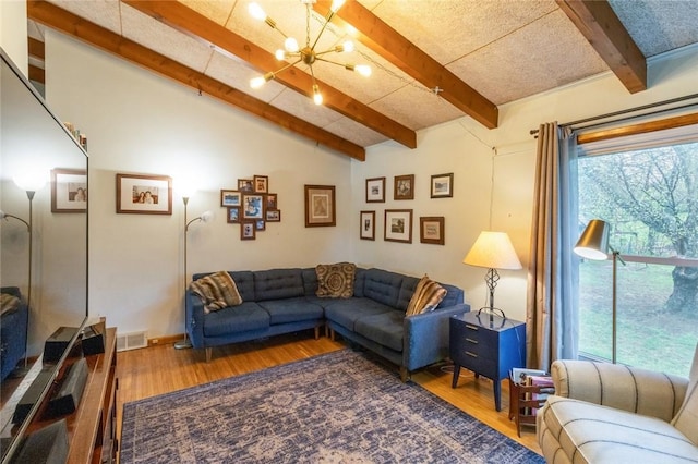living area featuring an inviting chandelier, visible vents, vaulted ceiling with beams, and wood finished floors