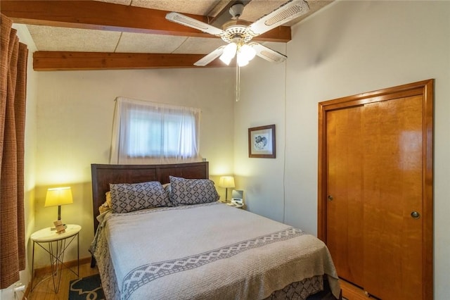 bedroom featuring a closet, a ceiling fan, and vaulted ceiling with beams