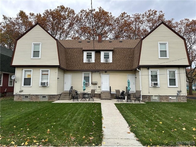 rear view of property with a gambrel roof, a shingled roof, a lawn, and entry steps