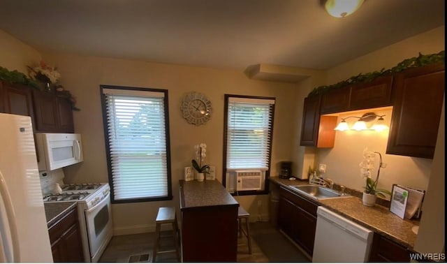 kitchen with a sink, white appliances, cooling unit, baseboards, and dark countertops