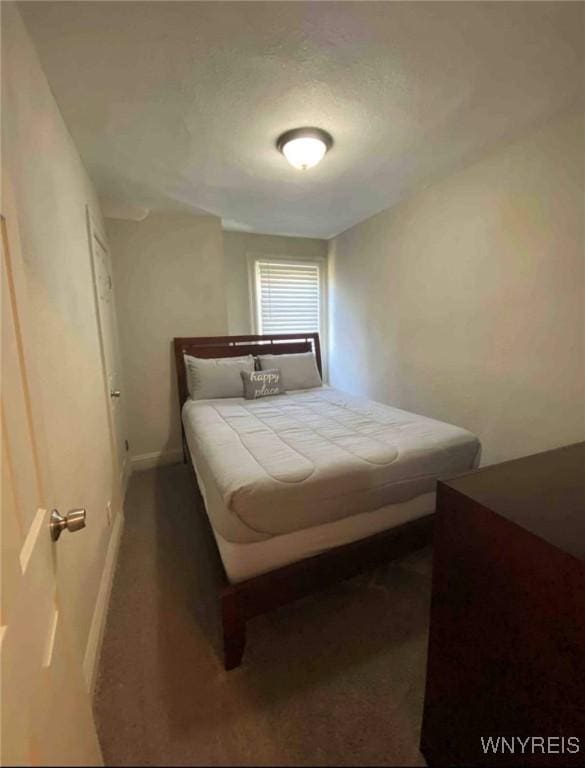 bedroom with baseboards and dark colored carpet