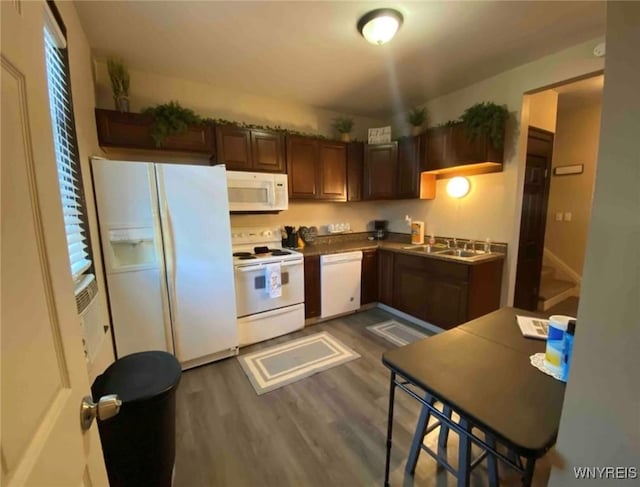 kitchen featuring dark wood-type flooring, a sink, and white appliances