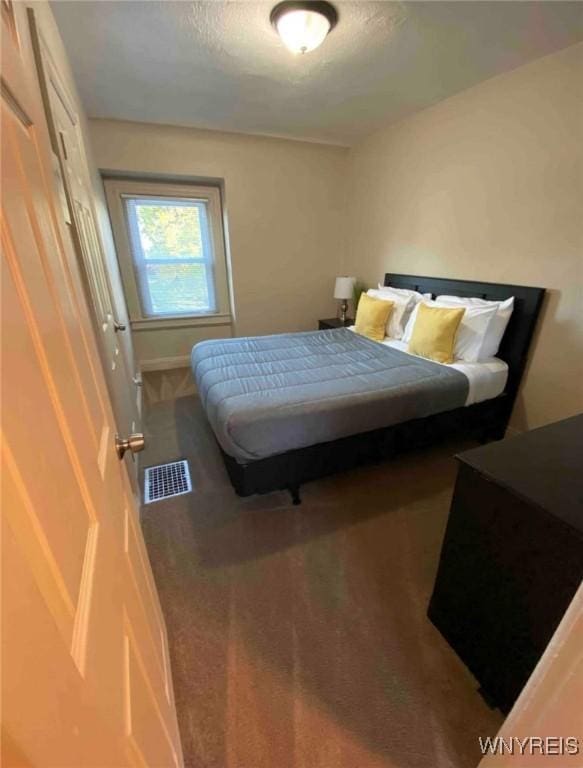 carpeted bedroom featuring baseboards and visible vents