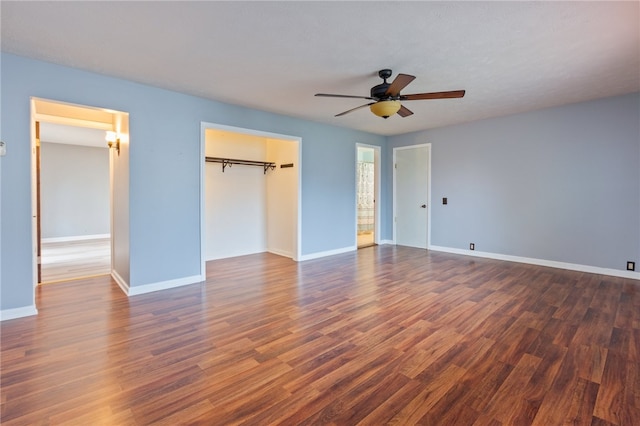 unfurnished bedroom featuring baseboards, a closet, a ceiling fan, and dark wood-style floors