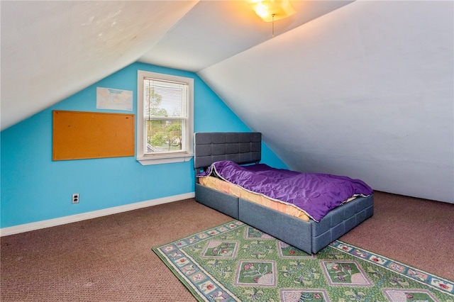 carpeted bedroom with baseboards and vaulted ceiling