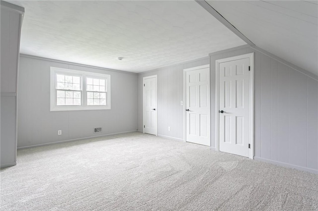 bonus room with baseboards, visible vents, and carpet