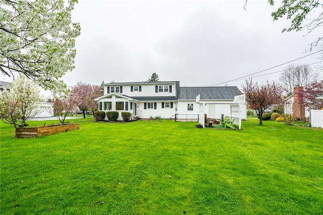 rear view of house featuring a lawn and fence