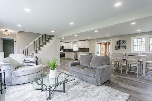 living area featuring light wood finished floors, stairway, and recessed lighting