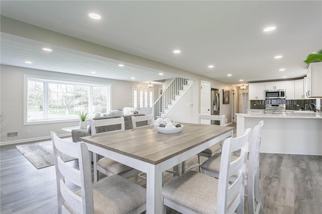 dining room with recessed lighting, baseboards, visible vents, stairway, and light wood-type flooring