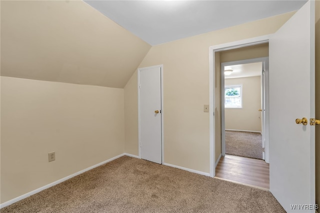 bonus room featuring carpet, baseboards, and vaulted ceiling