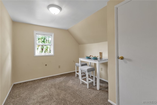 carpeted home office featuring vaulted ceiling and baseboards