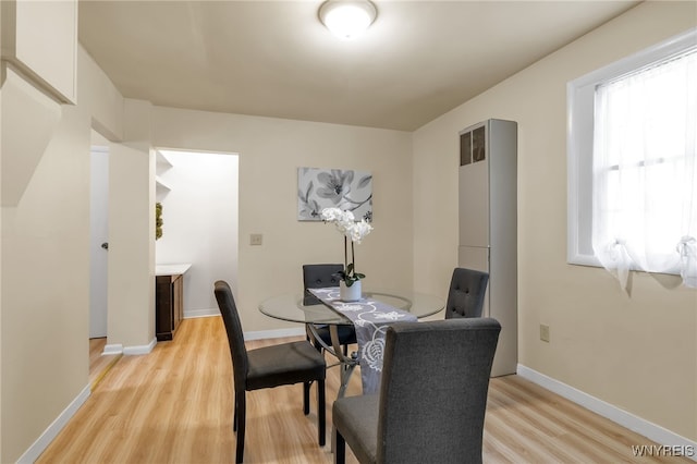 dining area with light wood finished floors and baseboards