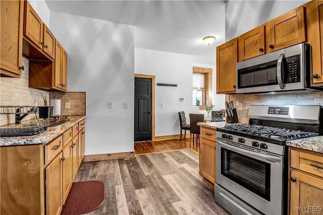 58 Park St, Buffalo, NY 14201 - kitchen featuring appliances with stainless steel finishes, a sink, tasteful backsplash, dark wood-style floors, and baseboards