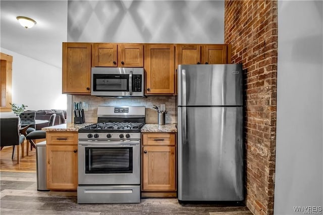 58 Park St, Buffalo, NY 14201 - kitchen featuring appliances with stainless steel finishes, dark wood finished floors, light stone countertops, and decorative backsplash