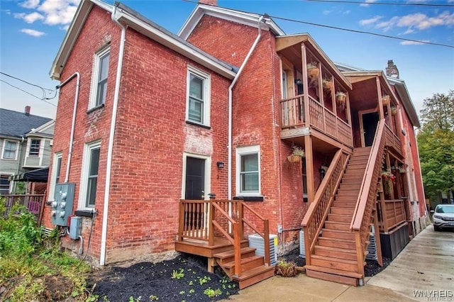58 Park St, Buffalo, NY 14201 - back of property with a chimney, brick siding, stairway, and a balcony