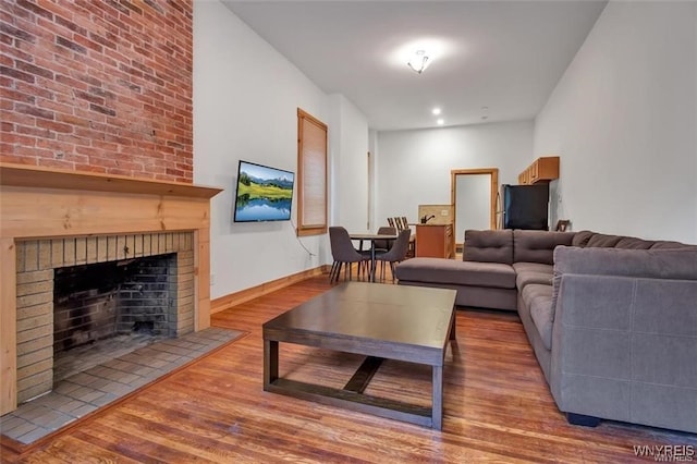 58 Park St, Buffalo, NY 14201 - living room featuring wood finished floors, a brick fireplace, and baseboards