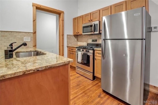 58 Park St, Buffalo, NY 14201 - kitchen featuring stainless steel appliances, a sink, tasteful backsplash, and light wood-style floors