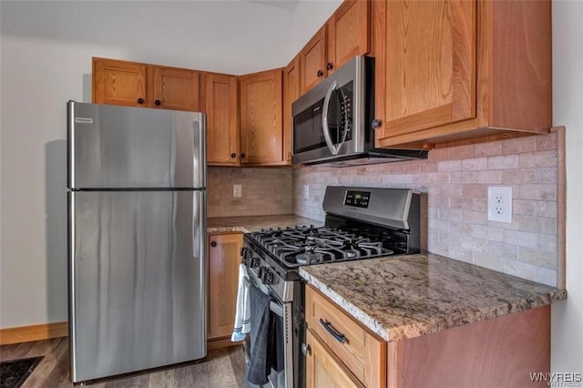 58 Park St, Buffalo, NY 14201 - kitchen featuring appliances with stainless steel finishes, tasteful backsplash, light stone counters, and brown cabinets