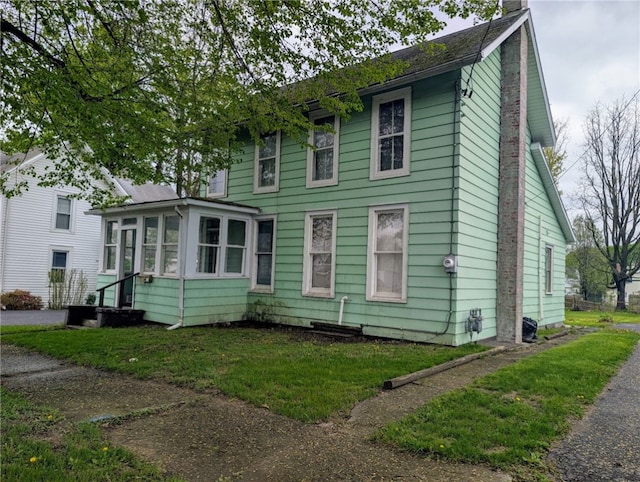 view of front facade with a sunroom and a chimney